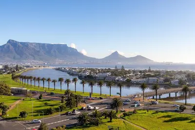 a city with palm trees and a body of water at Modern 1 Bedroom Table Mountain View Hideaway, Milnerton in Cape Town