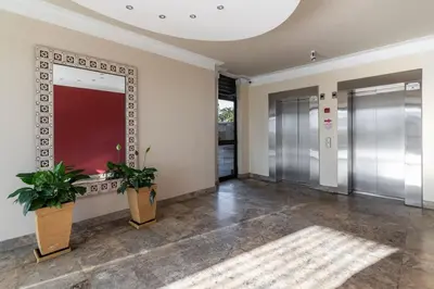 a hallway with two potted plants in a building at Modern 1 Bedroom Table Mountain View Hideaway, Milnerton in Cape Town