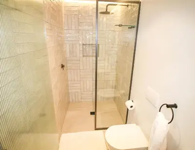 a bathroom with a glass shower with a toilet at Charming Apartment in Cape Winelands District in Stellenbosch