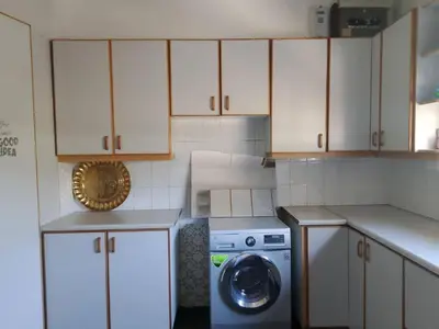 a small kitchen with a washing machine and cabinets at Guest Lodge on 12 Duminy in Bellville