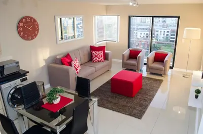 a living room with a couch and a table at Knightsbridge Luxury Apartments in Cape Town