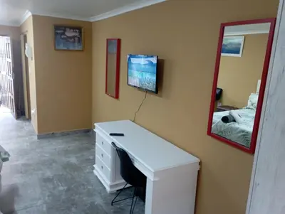 a bedroom with a white desk and a mirror at 8 Botha Goodwood the trout lodge in Elsiesrivier
