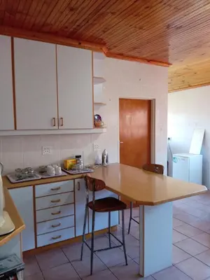 a kitchen with a wooden table and chairs in it at Beyond Expectation in Avondale