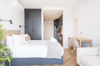 a bedroom with a bed and a living room at Paarl Superior Studio 230 With Onsite Parking in Paarl
