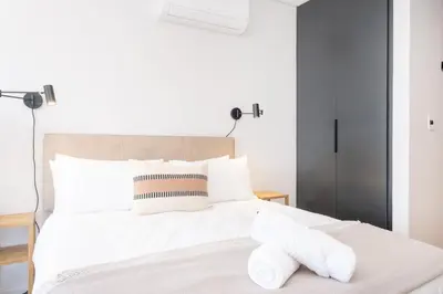 a bedroom with a white bed with towels on it at Paarl Superior Studio 230 With Onsite Parking in Paarl