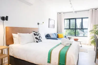 a bedroom with a large bed and a couch at Paarl Superior Studio 231 - With Onsite Parking & Comforts in Paarl