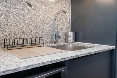 a kitchen counter with a sink and a faucet at Paarl Superior Studio 231 - With Onsite Parking & Comforts in Paarl