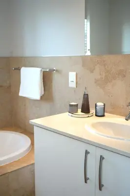 a bathroom with a sink and a toilet and a mirror at Modern Family Golf Lodge in Winelands Paradise in Paarl