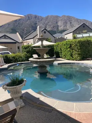 a fountain in the middle of a swimming pool at Villa 121 Franschhoek Lermitage in Franschhoek