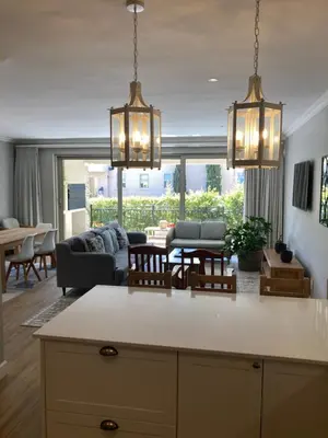 a kitchen with two chandeliers and a living room at Villa 121 Franschhoek Lermitage in Franschhoek