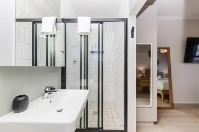 a white bathroom with a sink and a mirror at Cape On Viola 13-Blouberg Gem Walk to Kite Beach & Ocean Views in Cape Town