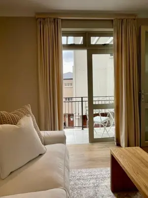 a living room with a couch and a balcony at Villa Mignon in Franschhoek