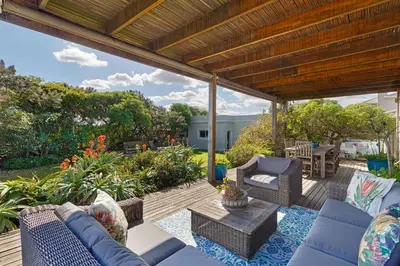 a patio with blue furniture on a wooden deck at Dune Pavillion Beach Villa-Where the Ocean Meets the Mountain in Cape Town