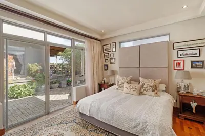 a bedroom with a bed and a large window at Dune Pavillion Beach Villa-Where the Ocean Meets the Mountain in Cape Town