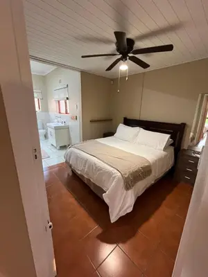 a bedroom with a bed and a ceiling fan at Leliefontein Eco Cottage and Glamping in Paarl