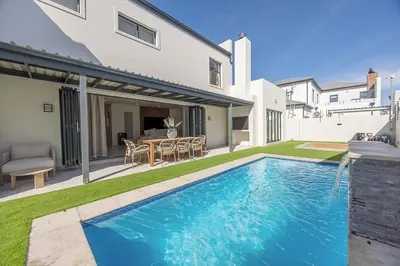a swimming pool in the backyard of a house at Cape Town Bliss in Sandown in Cape Town