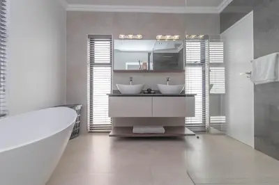 a bathroom with two sinks and a bath tub at Executive 1 bedroom Cottage, with aircon, king size bed and modern bathroom in Hermanus
