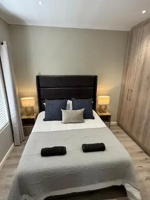 a bedroom with a large bed with two pillows on it at Avalon 4 Bed 4 Bath House in residential security Estate in Stellenbosch