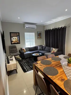 a living room with a couch and a table at Avalon 4 Bed 4 Bath House in residential security Estate in Stellenbosch