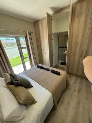 a bedroom with a large bed with a large window at Avalon 4 Bed 4 Bath House in residential security Estate in Stellenbosch