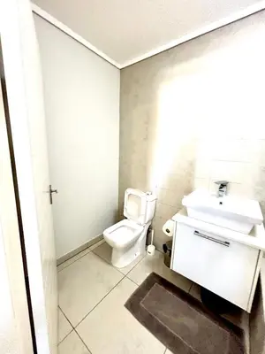 a bathroom with a white toilet and a sink at Luxe watersedge apartment in Cape Town