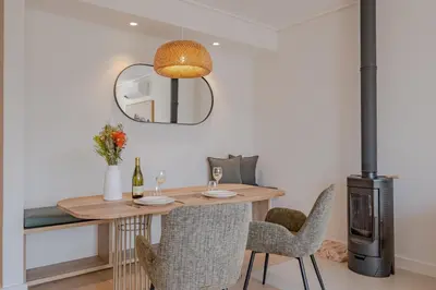 a dining room with a table and chairs and a mirror at Oakwood Hermanus in Hermanus