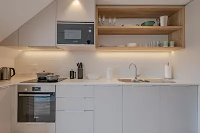 a kitchen with white cabinets and a sink at Oakwood Hermanus in Hermanus