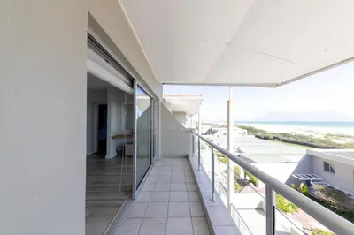 a balcony with a view of the ocean at Dolphin Beach C110 Beachfront Beauty in Cape Town