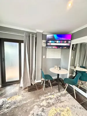 a dining room with a table and chairs and a window at Apartment in Bellville - self-catering in Bellville