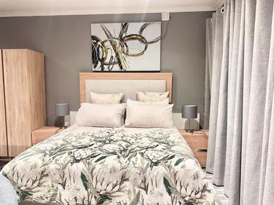 a bedroom with a large bed and two lamps at Apartment in Bellville - self-catering in Bellville