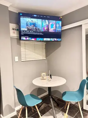 a room with a table and two chairs and a tv at Apartment in Bellville - self-catering in Bellville