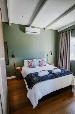 a bedroom with a large bed with two pillows on it at Mountain-View Stay, Aircon, WiFi, Parking in Somerset West