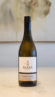 a bottle of wine sitting on a table at De Waal Grandeur Apartment in Stellenbosch