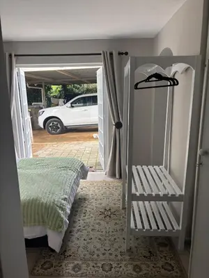 a bedroom with a bed and a car in a garage at The Dragonfly in Paarl