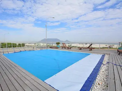 a swimming pool on top of a building at Cape Town Beachfront Accommodation in Blouberg in Bloubergstrand