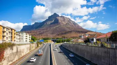 a highway with a mountain in the background at Obs Centre The Lookout in Cape Town