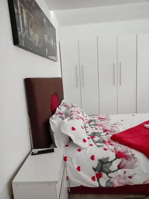 a bedroom with a bed with a red and white comforter at Jorash Guesthouse in Cape Town