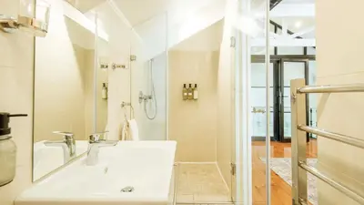 a white bathroom with a sink and a shower at Waymaker Cottage in Franschhoek