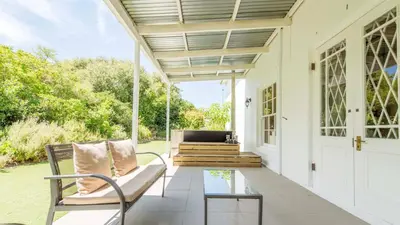 a porch with a couch and a glass table at Waymaker Cottage in Franschhoek