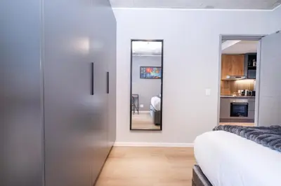a bedroom with a sliding door and a mirror at 317 Riverlands - Lux 1 bedroom Apartment in Cape Town