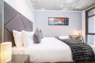 a bedroom with a large white bed and a window at 317 Riverlands - Lux 1 bedroom Apartment in Cape Town