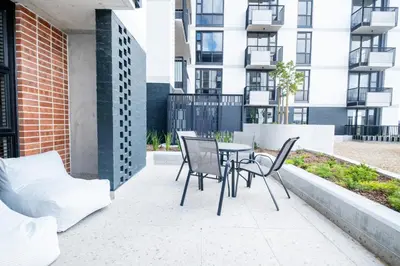 a patio with a table and chairs and a building at 317 Riverlands - Lux 1 bedroom Apartment in Cape Town