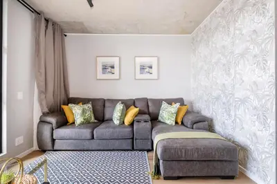 a living room with a couch and yellow pillows at 318 Riverlands - Lux 1 bedroom Apartment in Cape Town