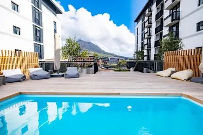 a swimming pool in the middle of a courtyard with buildings at 318 Riverlands - Lux 1 bedroom Apartment in Cape Town