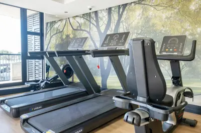 a gym with a treadmill in front of a window at 318 Riverlands - Lux 1 bedroom Apartment in Cape Town