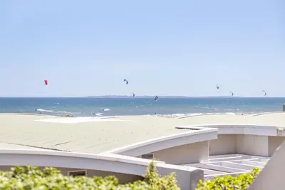 a view of a beach with the ocean in the background at Beautiful & Modern Dolphin Beach CG12 by HMH in Cape Town