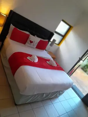 a bedroom with a large bed with red and white pillows at Neo & Ruks excellent Rooms in Goodwood