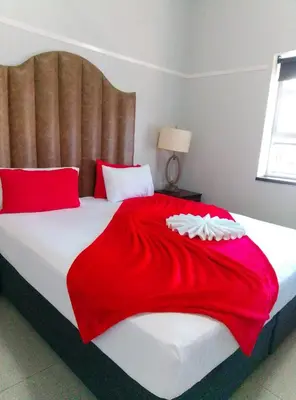 a bedroom with a large bed with a red blanket at Neo & Ruks excellent Rooms in Goodwood