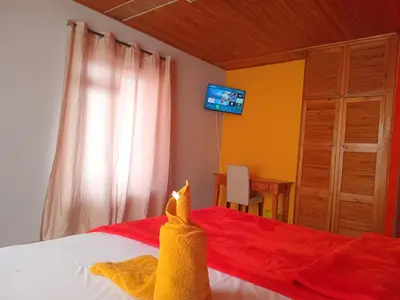 a bedroom with a bed and a tv on the wall at Neo & Ruks excellent Rooms in Goodwood