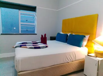a bedroom with a large white bed with a window at Neo & Ruks excellent Rooms in Goodwood
